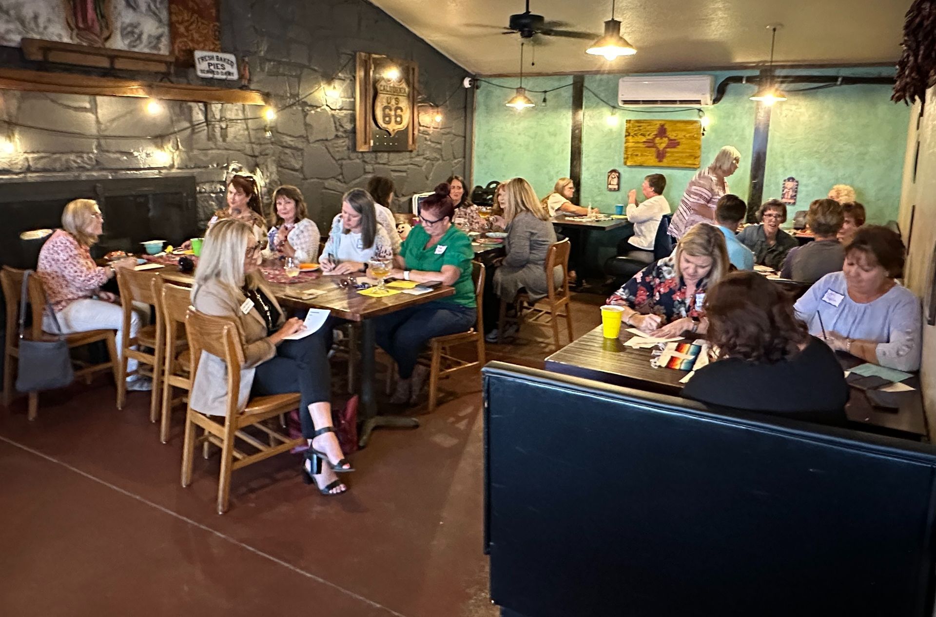 A group of people are sitting at tables in a restaurant.
