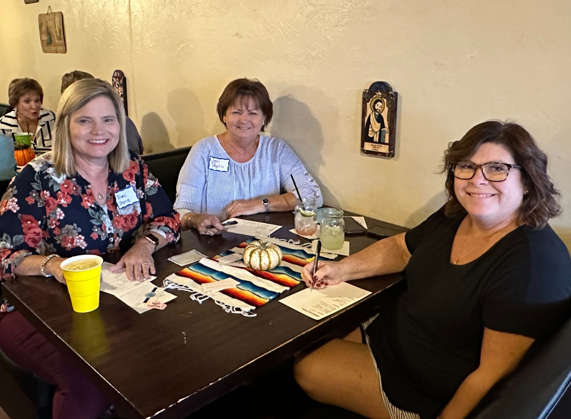 Three women are sitting at a table in a restaurant.