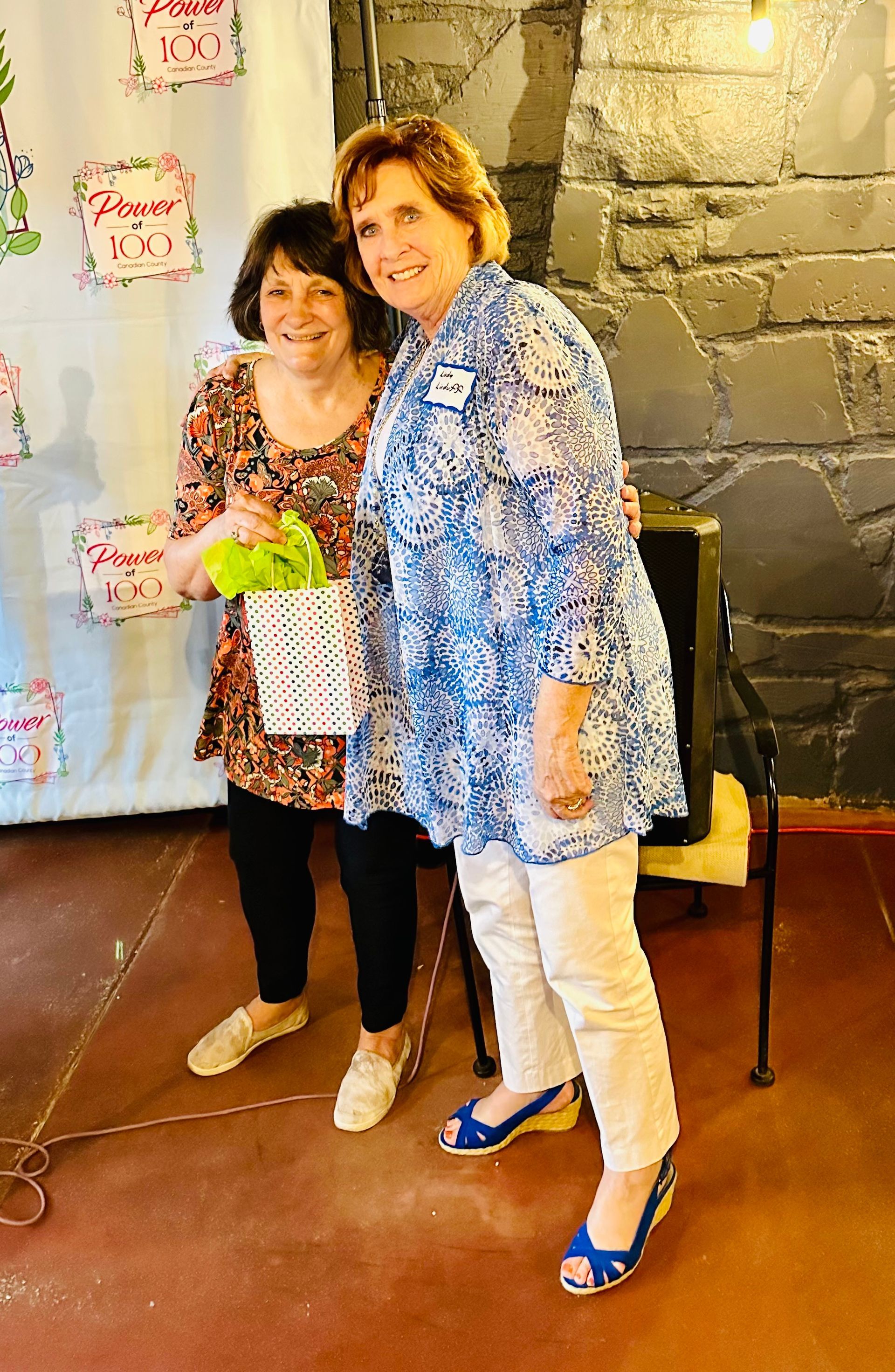 Two women are standing next to each other in a room.