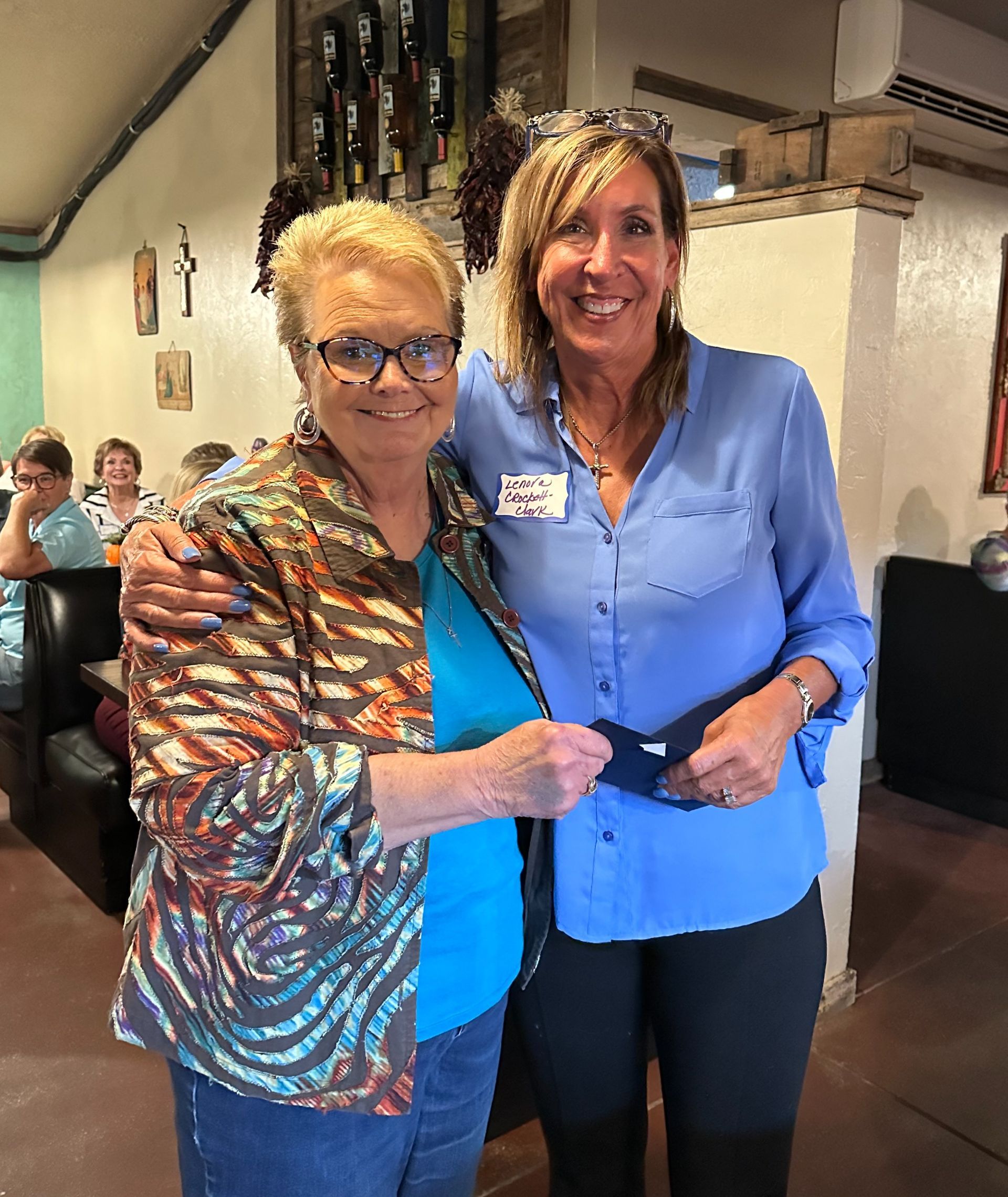 Two women are posing for a picture in a restaurant