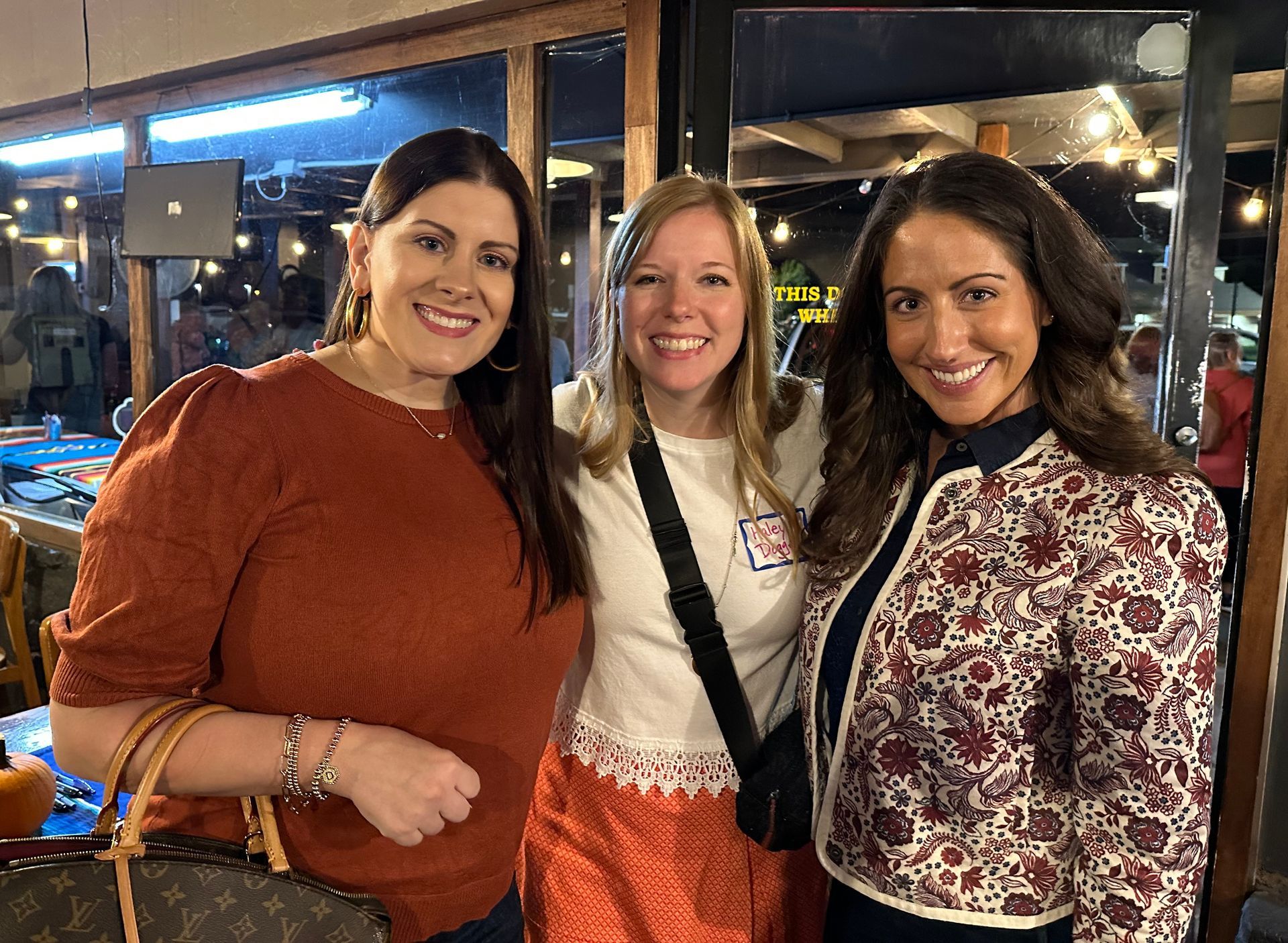 Three women are posing for a picture together in a room.