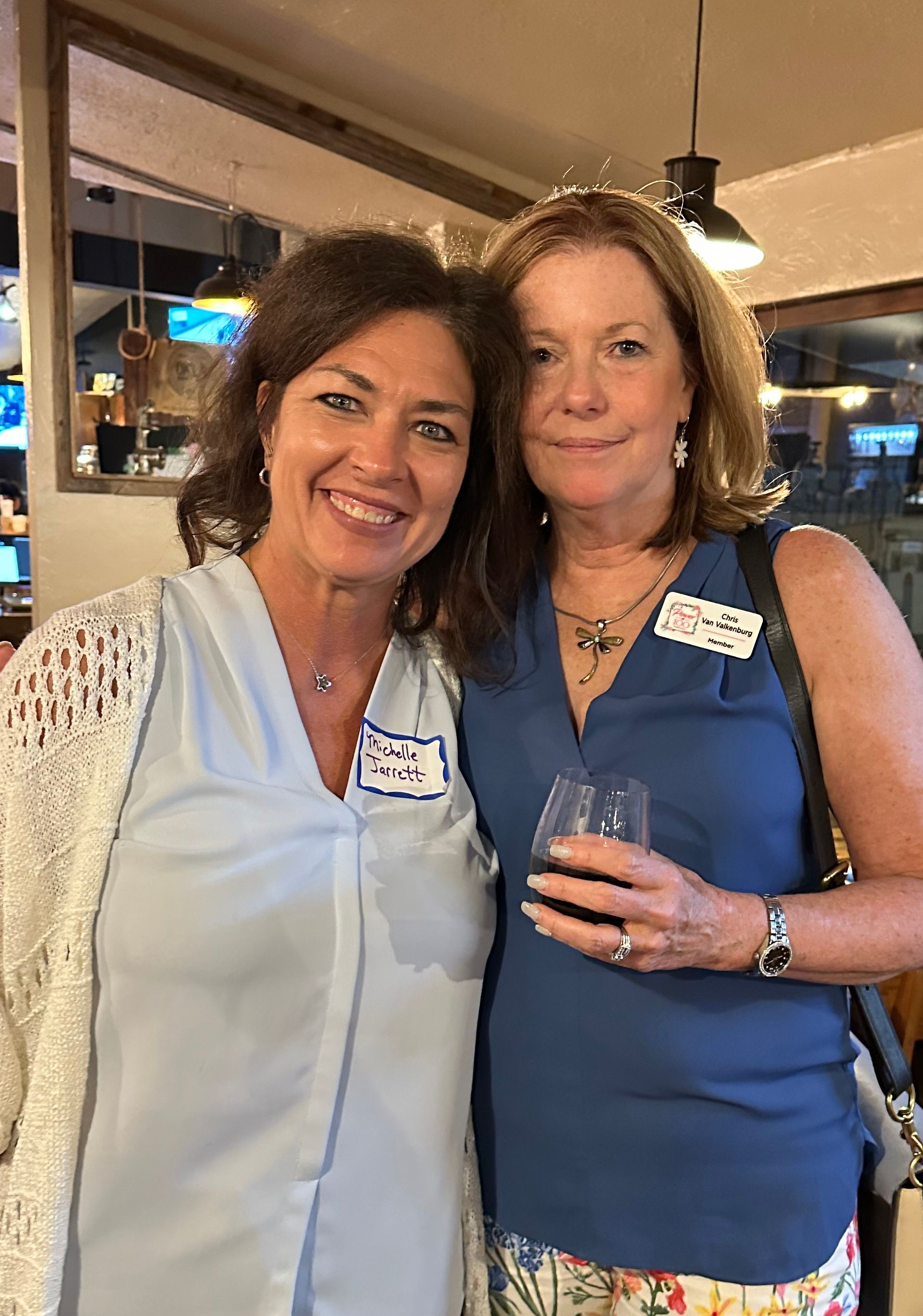 Two women are posing for a picture together in a restaurant.