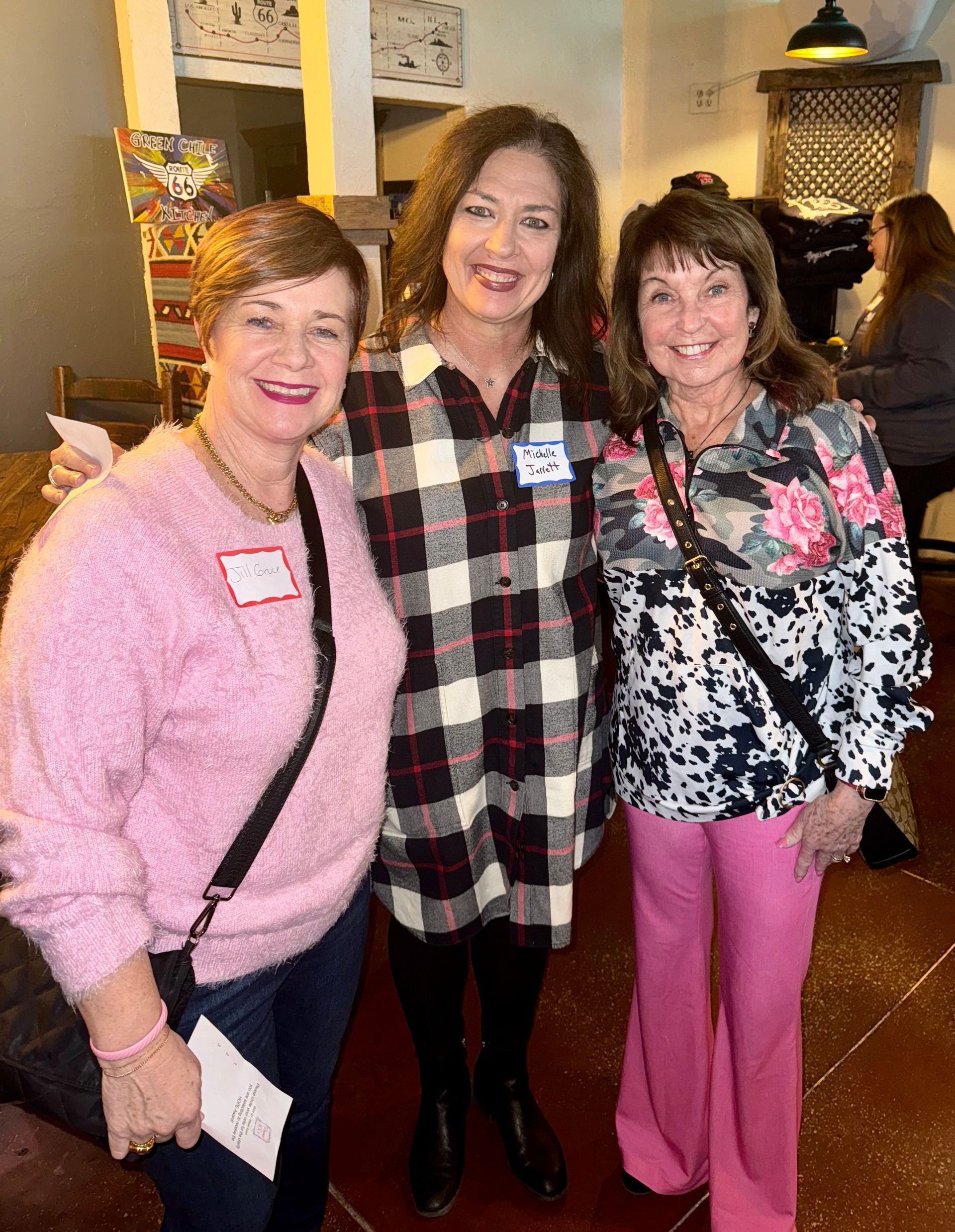 Three women are posing for a picture together in a room.