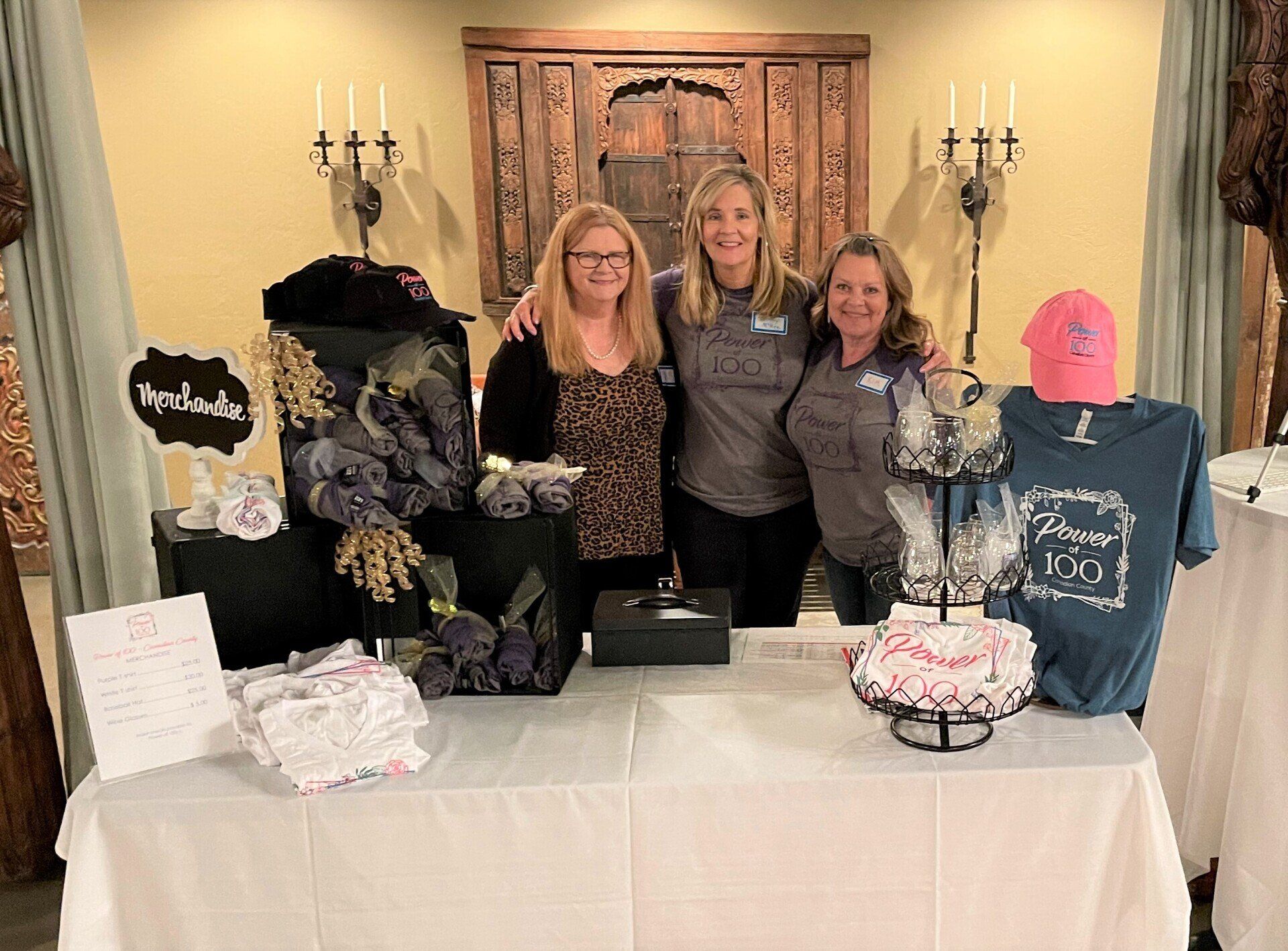 A group of women are posing for a picture in front of a table.