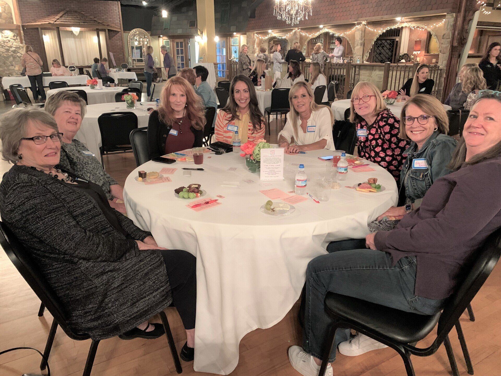A group of women are sitting around a table in a restaurant.