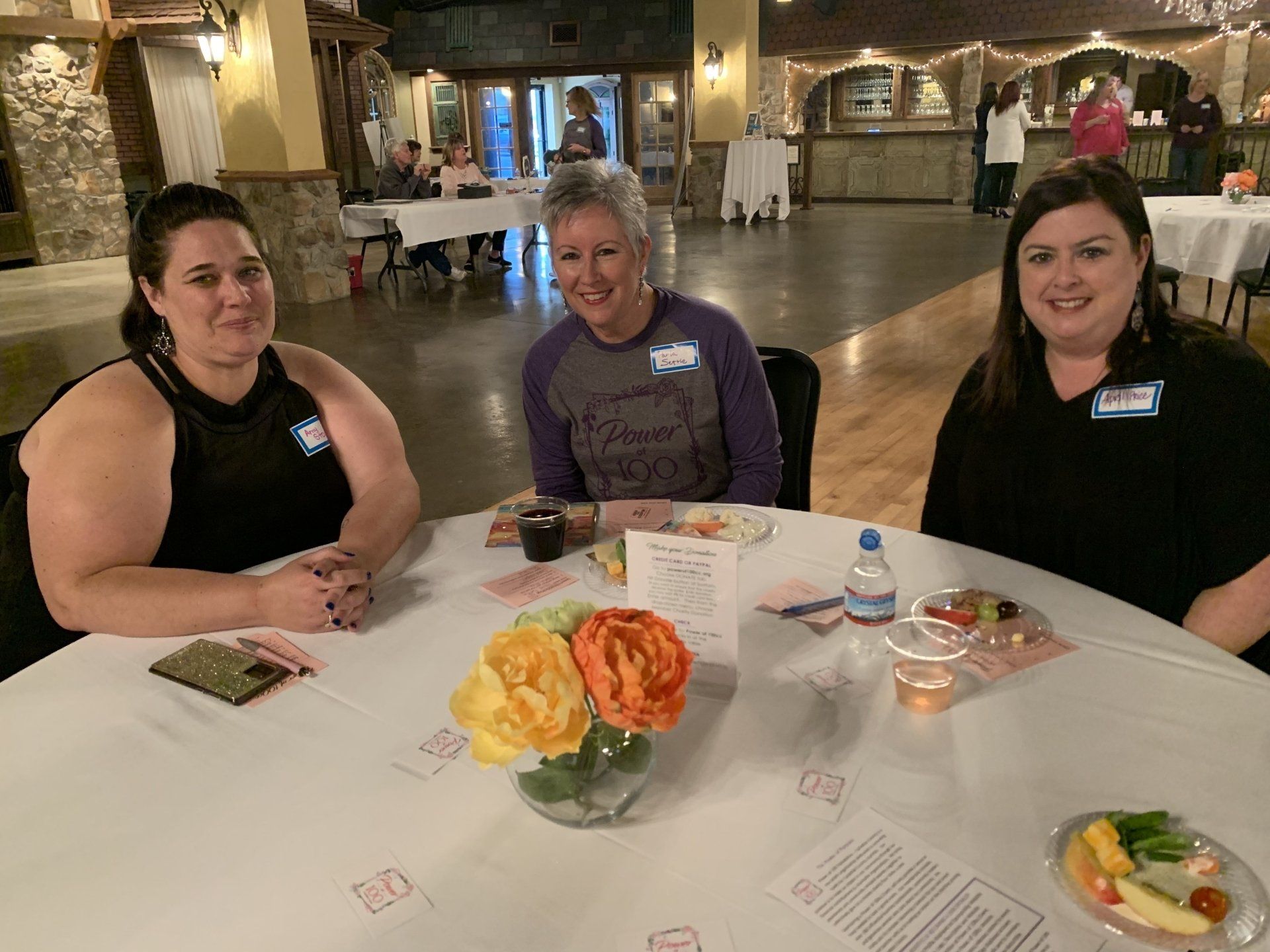 Three women are sitting at a table with plates of food.