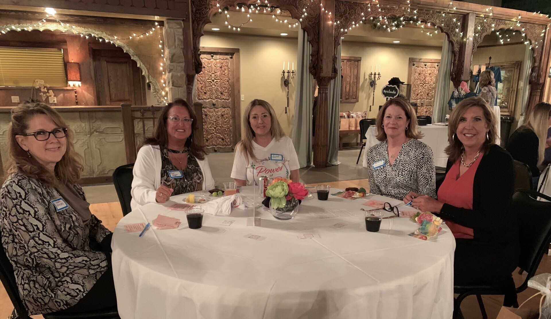 A group of women are sitting at a table with plates of food.