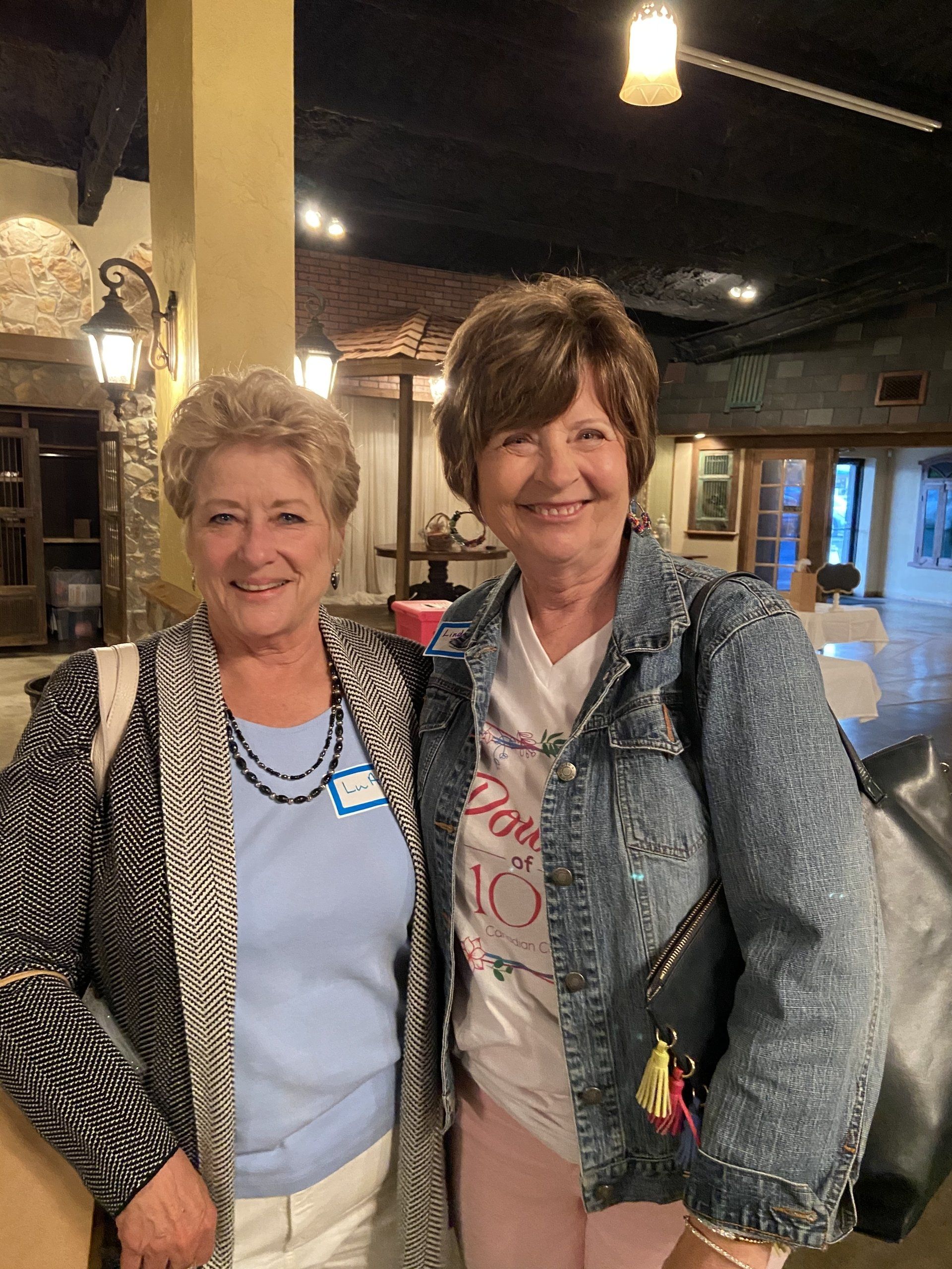 Two older women are posing for a picture in a restaurant
