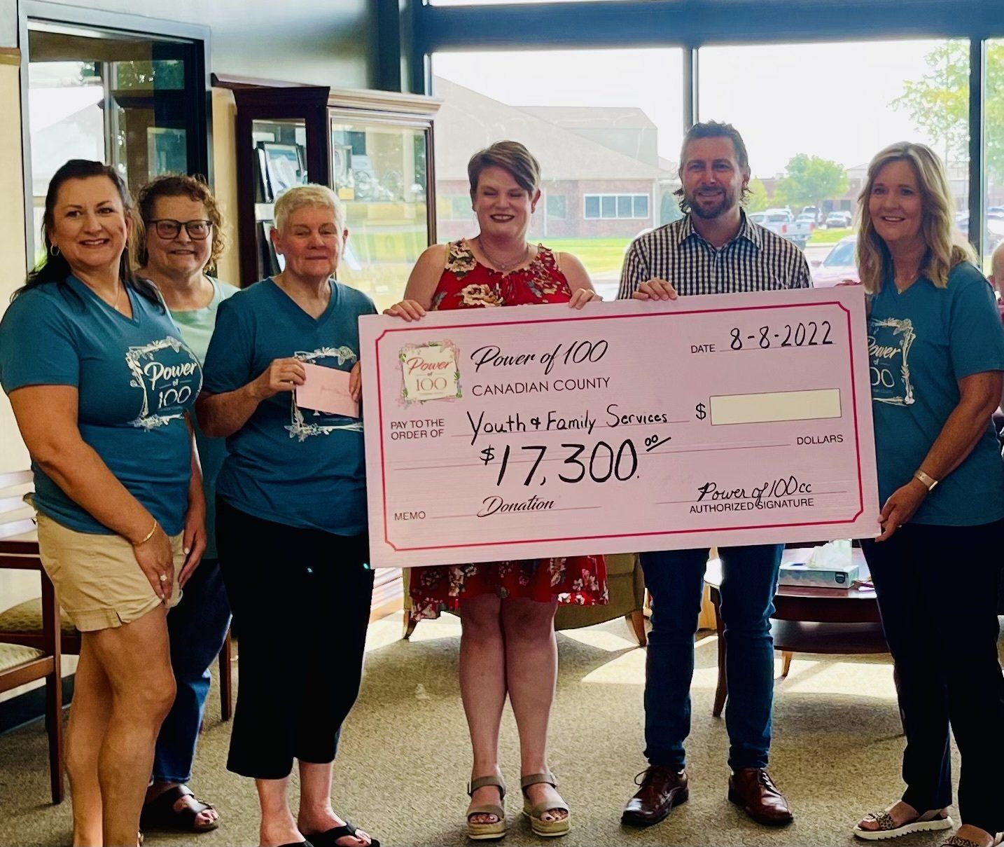 A group of people holding a check that says 17.300 on it