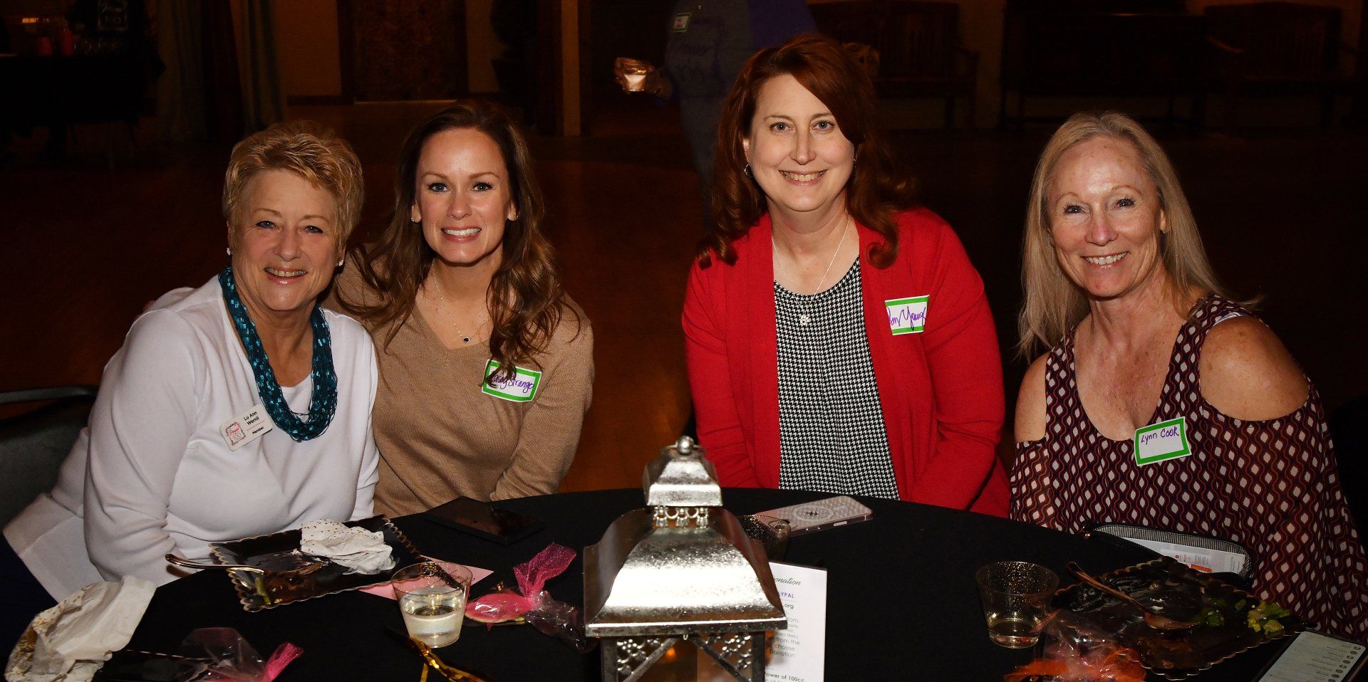 A group of women are sitting at a table smiling for a picture.