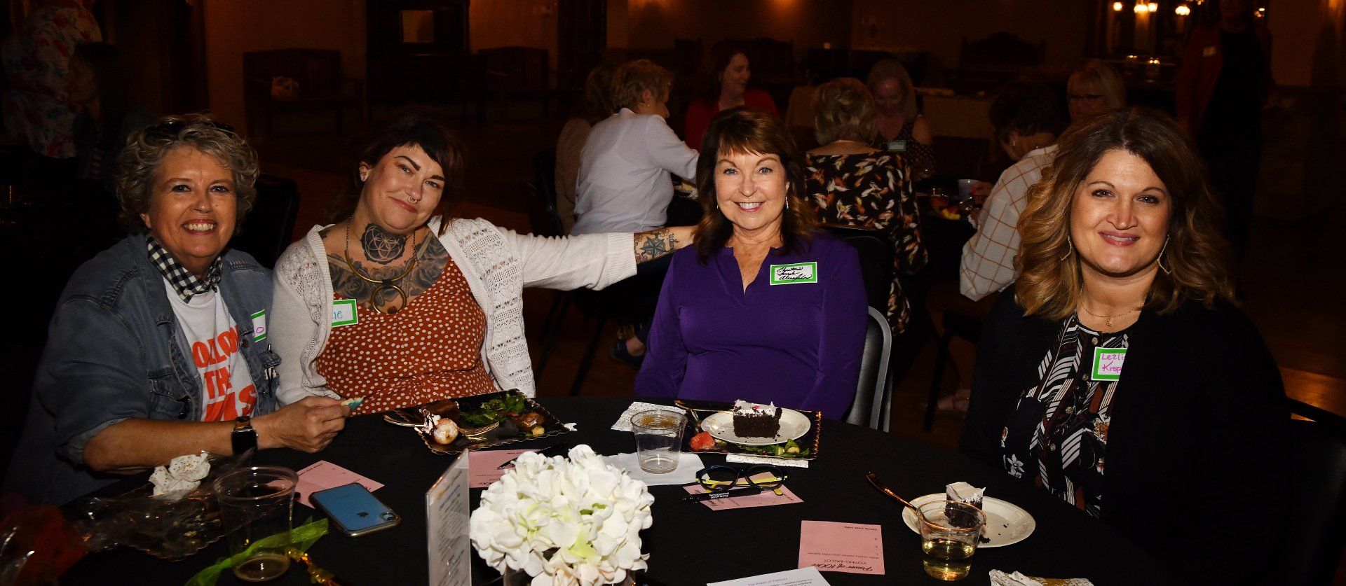 A group of women are sitting at a table in a room.
