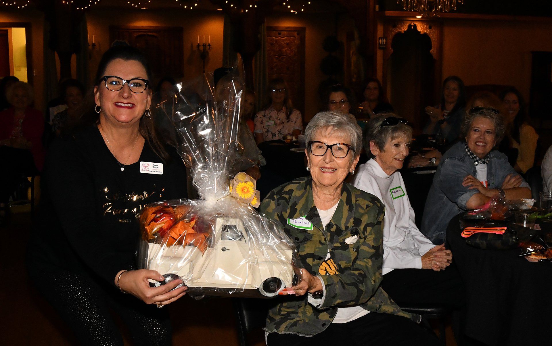 A woman is holding a basket of food in front of a group of people.