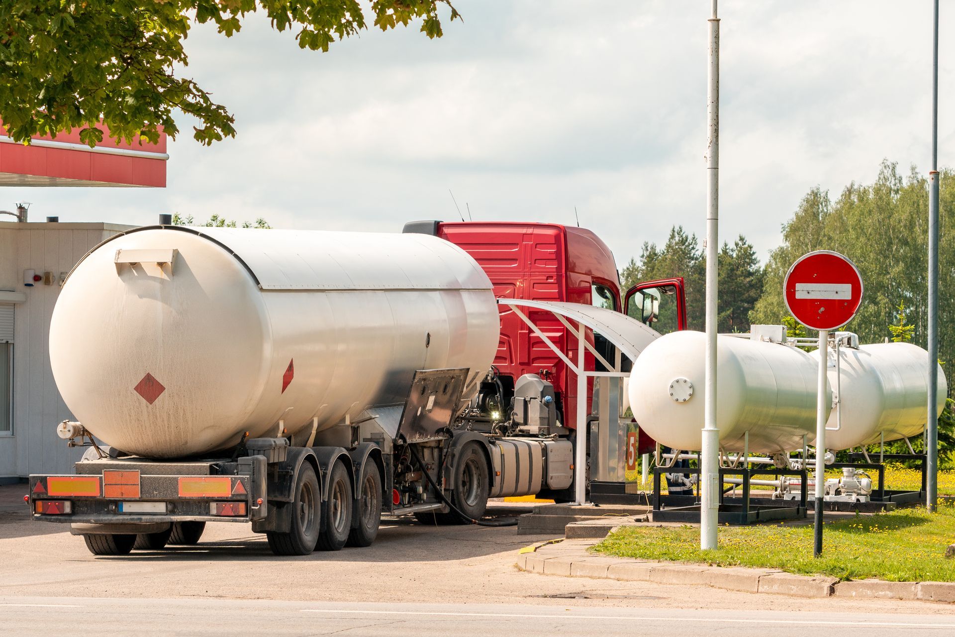 A tanker truck transporting a large gas tank for fuel delivery. A tanker truck transporting a large gas tank for fuel delivery.