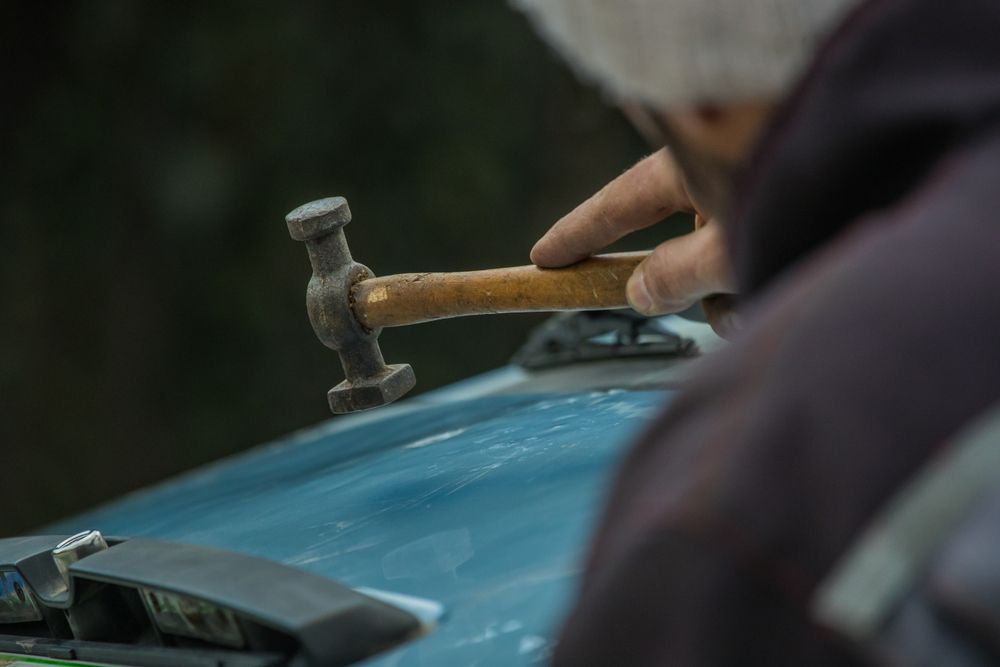 A Person Is Using A Hammer To Fix A Car — Lyons Street Paint Panel in Redlynch, QLD