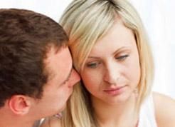 Un hombre le susurra algo al oído a una mujer.