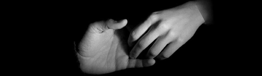 Una fotografía en blanco y negro de una persona sosteniendo la mano de otra.