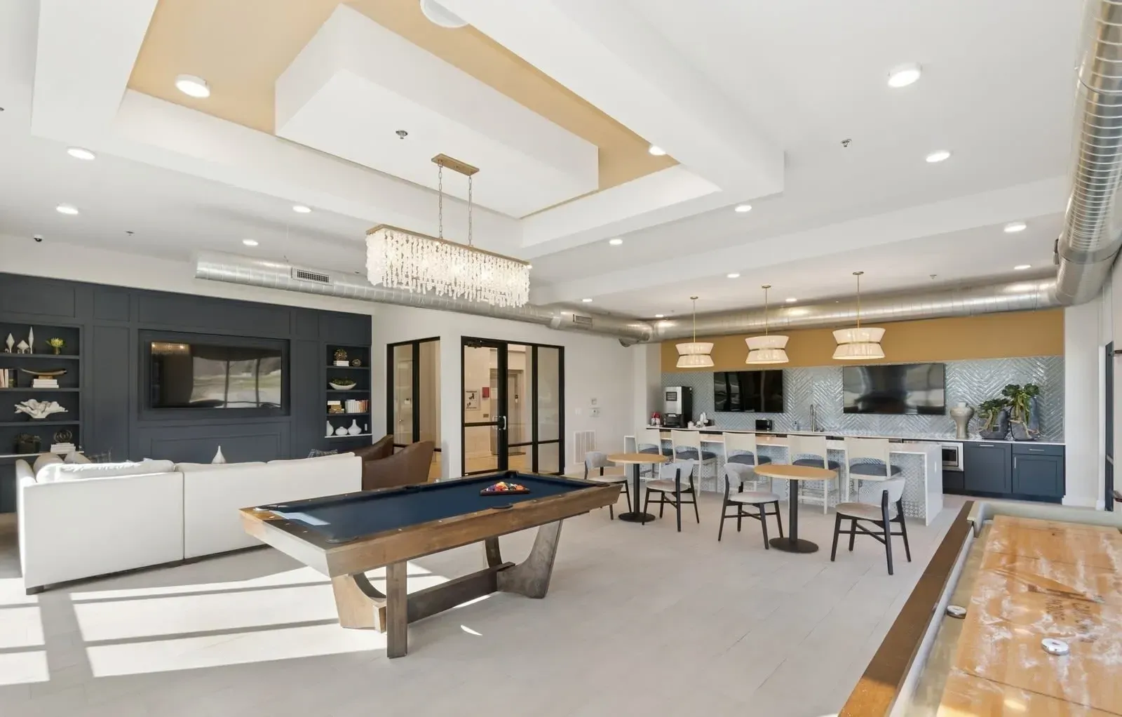 Spacious modern community lounge with a pool table, seating, and a coffee-bar area. Step inside our spacious one-bedroom apartments in Rowlett, TX and find the layout that fits your lifestyle—book a tour.