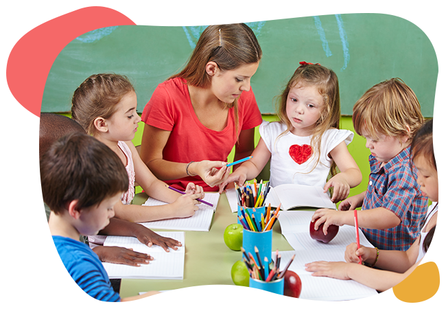 A group of children are sitting around a table with a teacher.