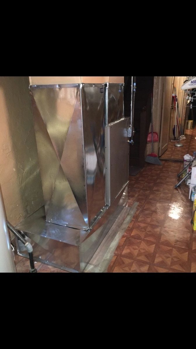 A room with a stove and a mirror on the floor.