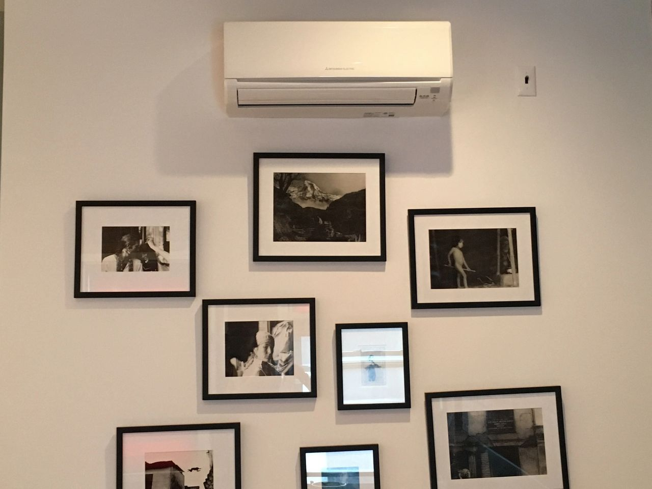 A wall with a bunch of framed pictures on it