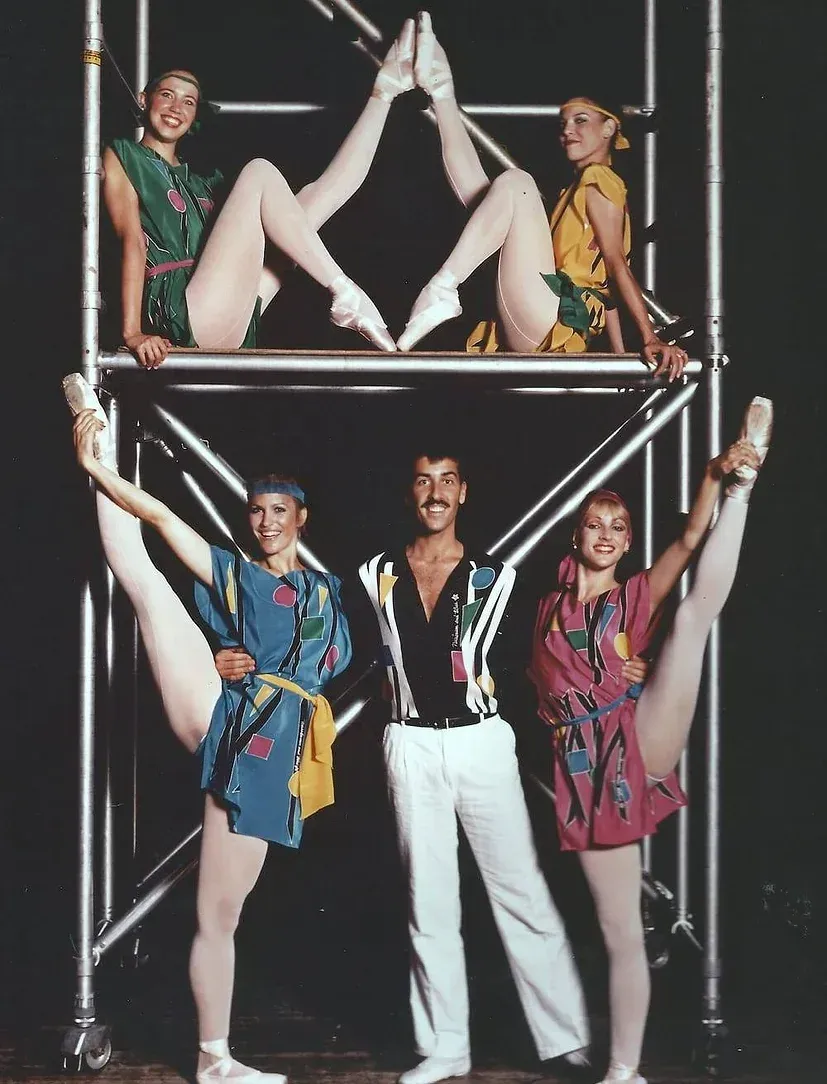 A group of people standing on a scaffolding with their legs in the air