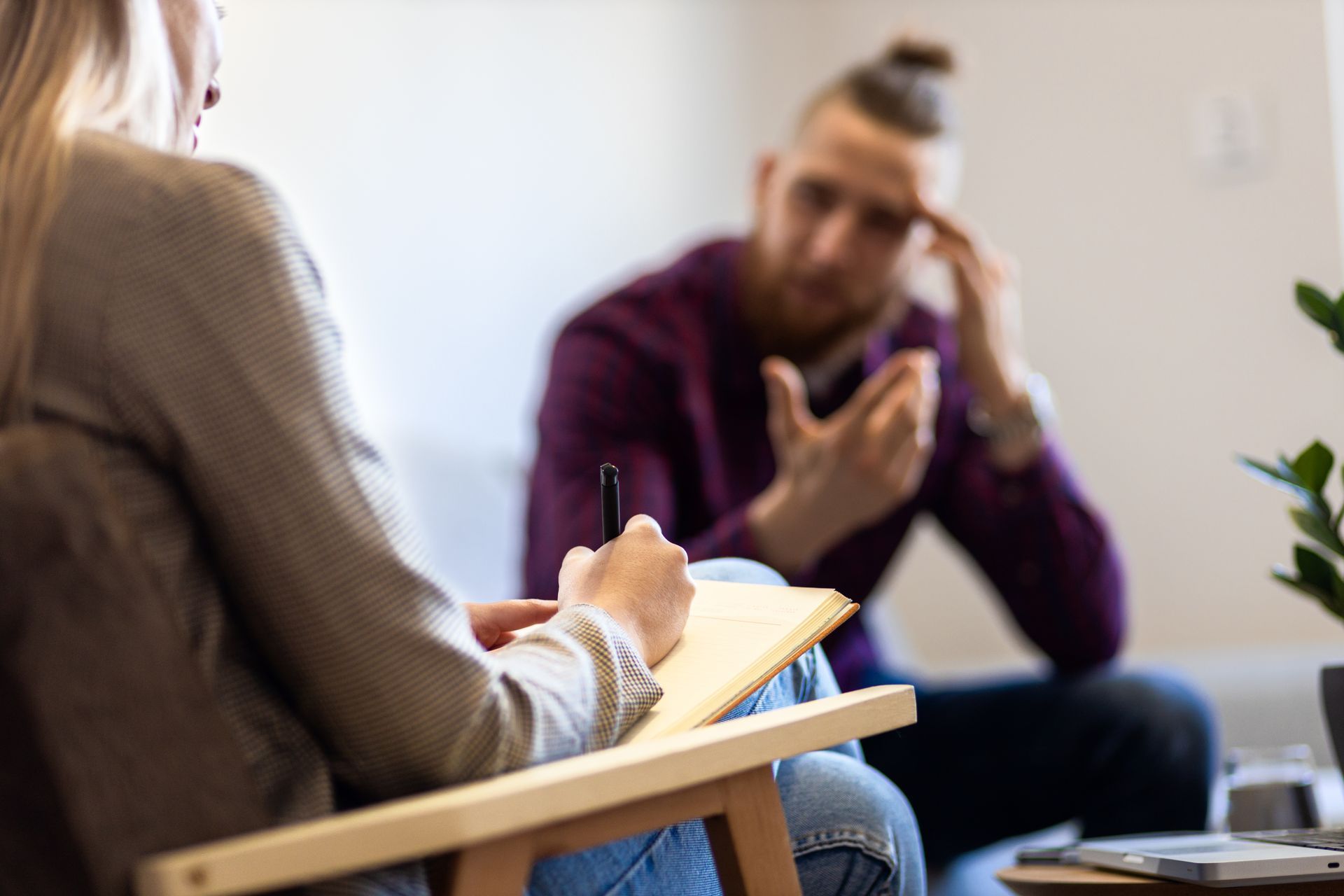 A woman is sitting in a chair talking to a man.