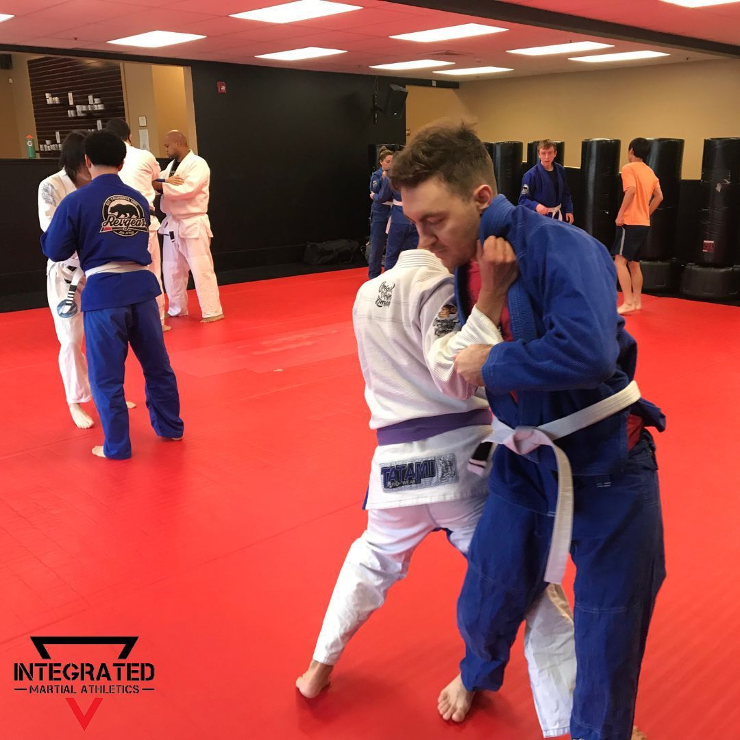 A group of men are practicing martial arts in a gym with integrated written on the bottom