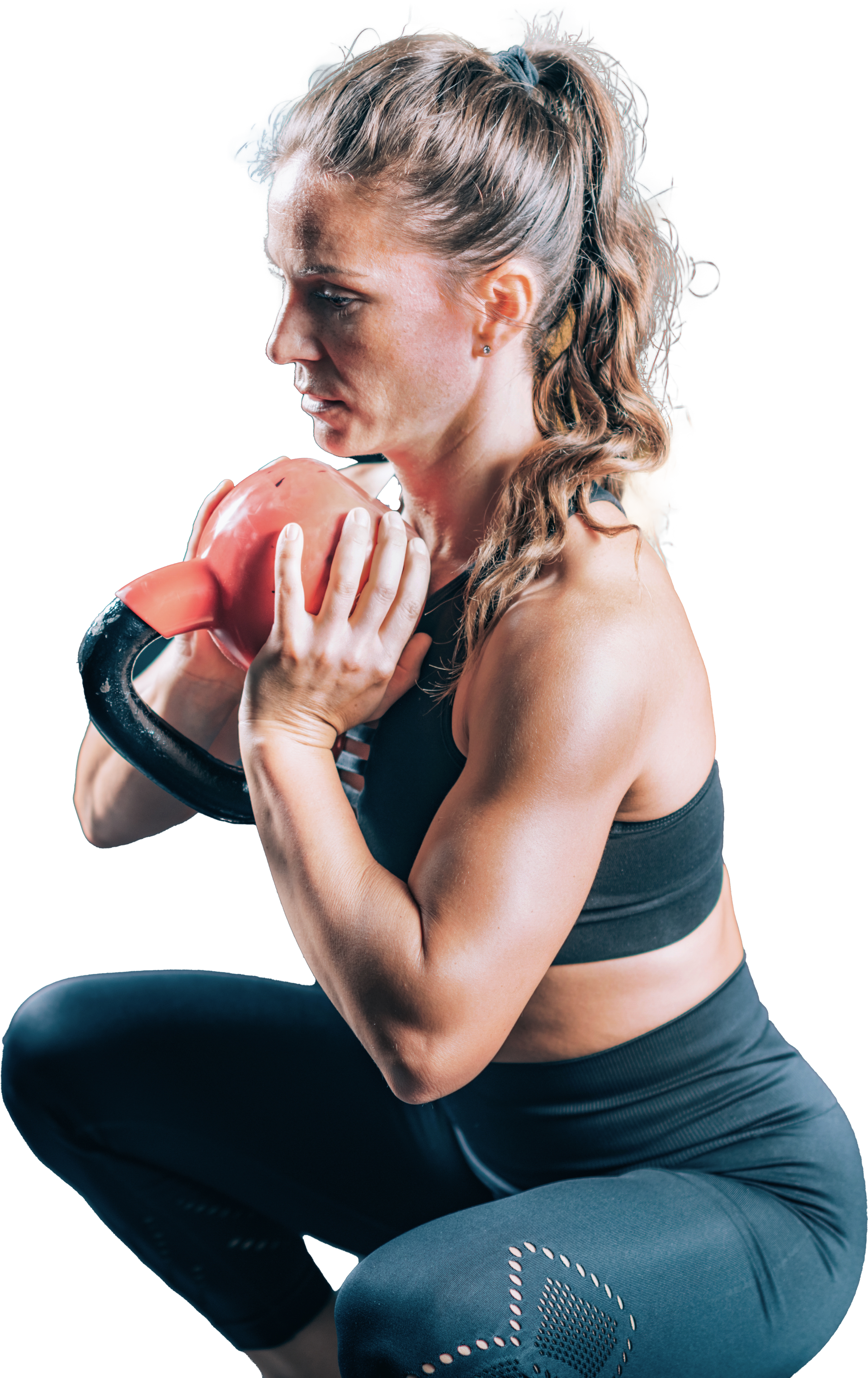 A woman is squatting down while holding a kettlebell in her hands.