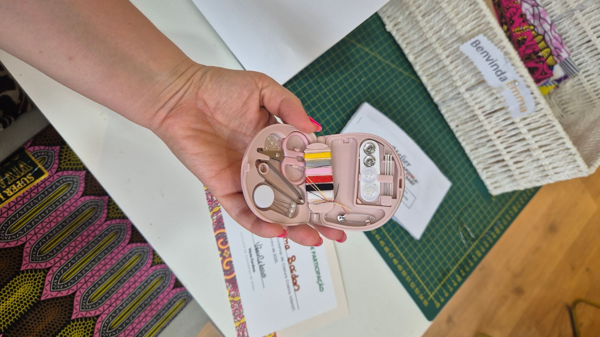 Uma pessoa está segurando um pequeno kit de costura na mão.