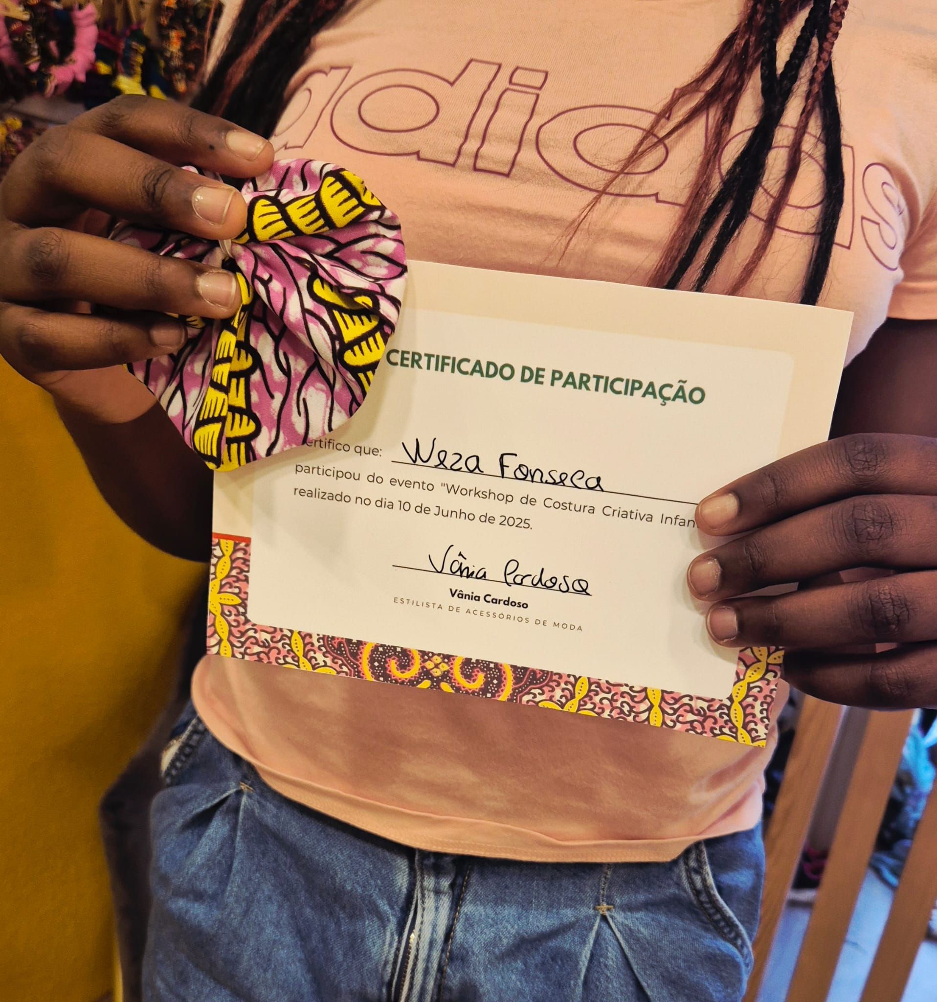 Uma pessoa vestindo uma camisa da Adidas está segurando um certificado