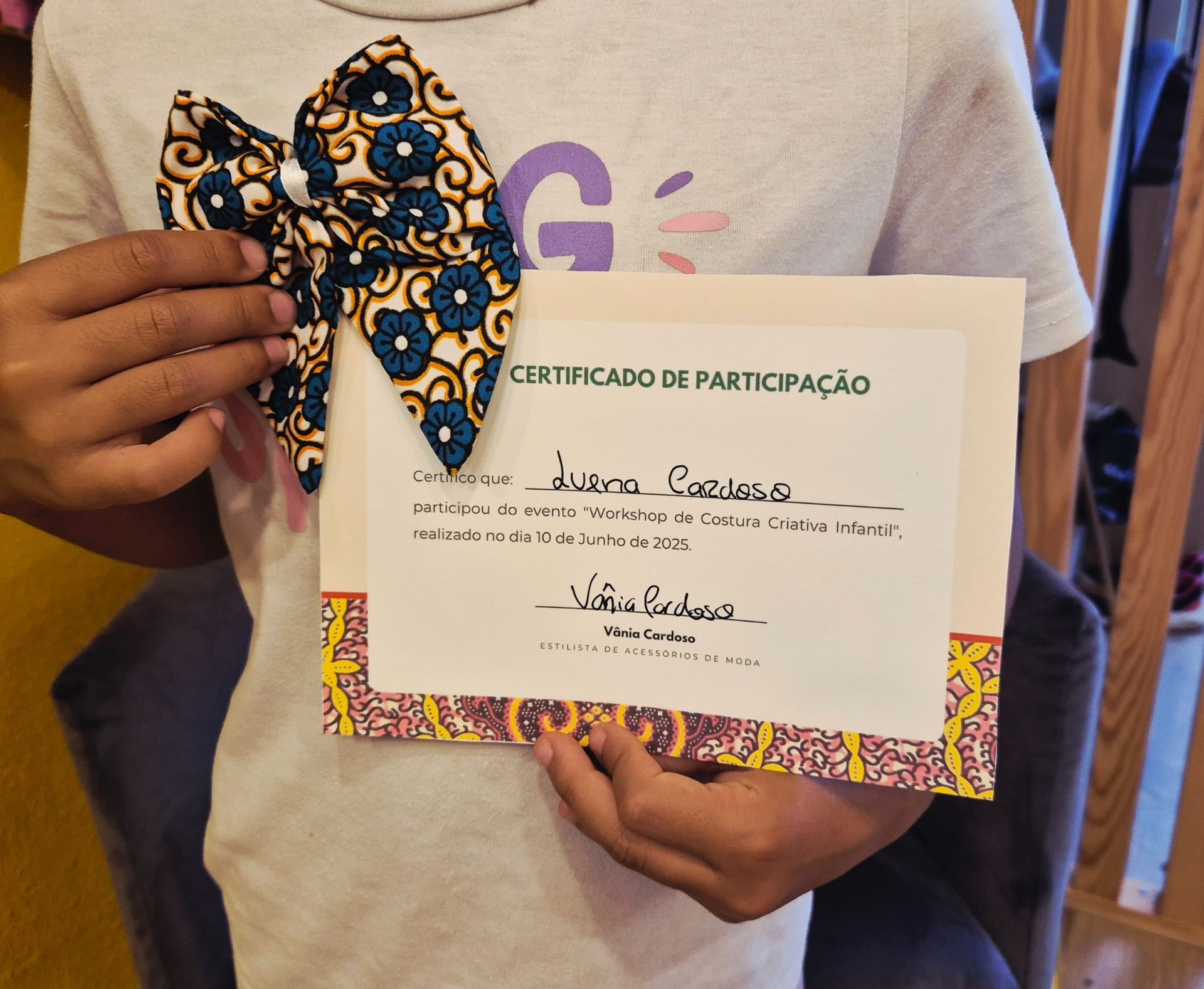 Uma pessoa está segurando um certificado e uma gravata borboleta