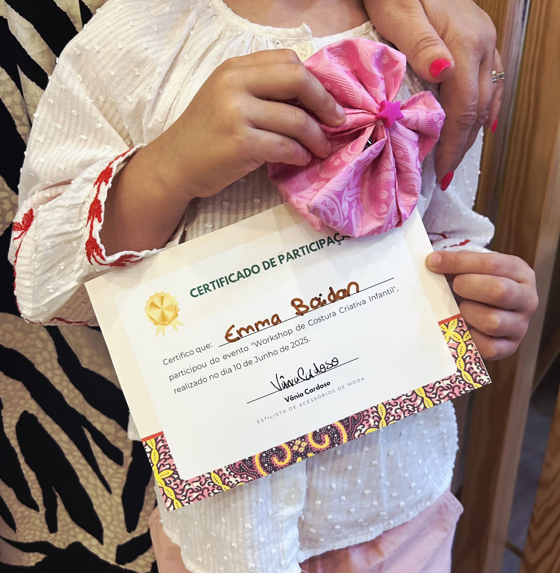 Uma garotinha está segurando um certificado para emma baiton