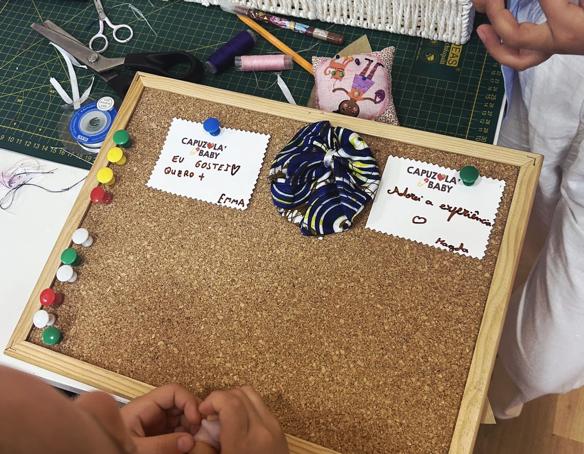 Uma pessoa está segurando um quadro de cortiça com alfinetes
