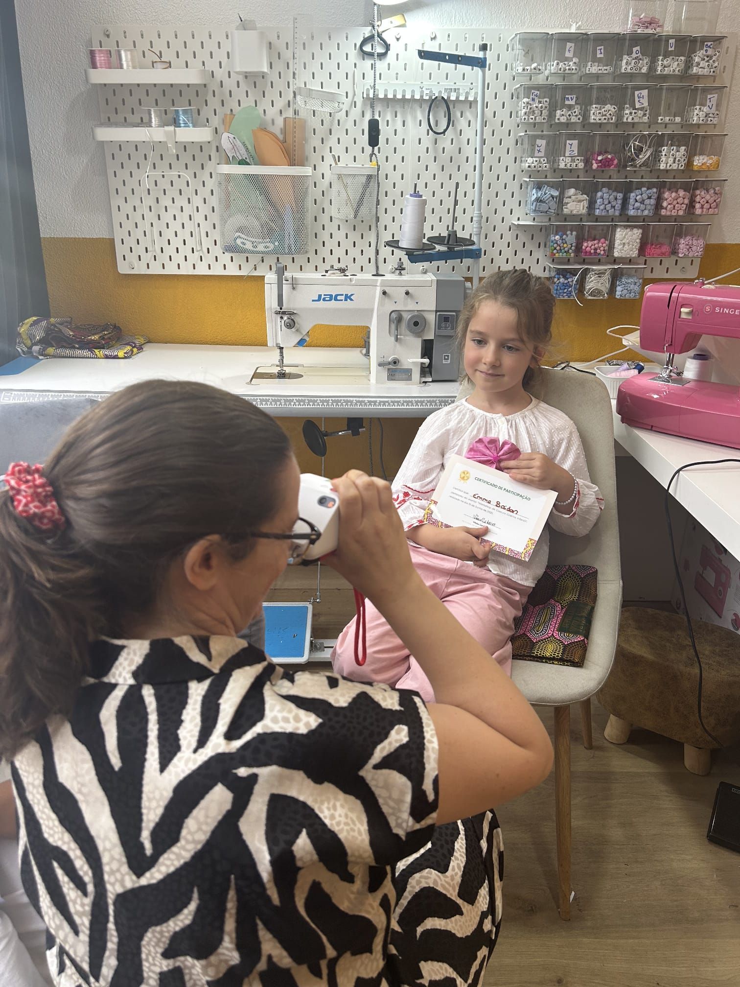 Uma mulher está ensinando uma menina a usar uma máquina de costura.