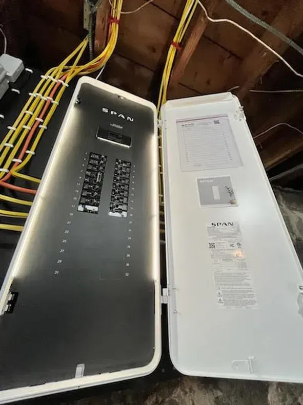 a black and white electrical panel with yellow wires coming out of it .