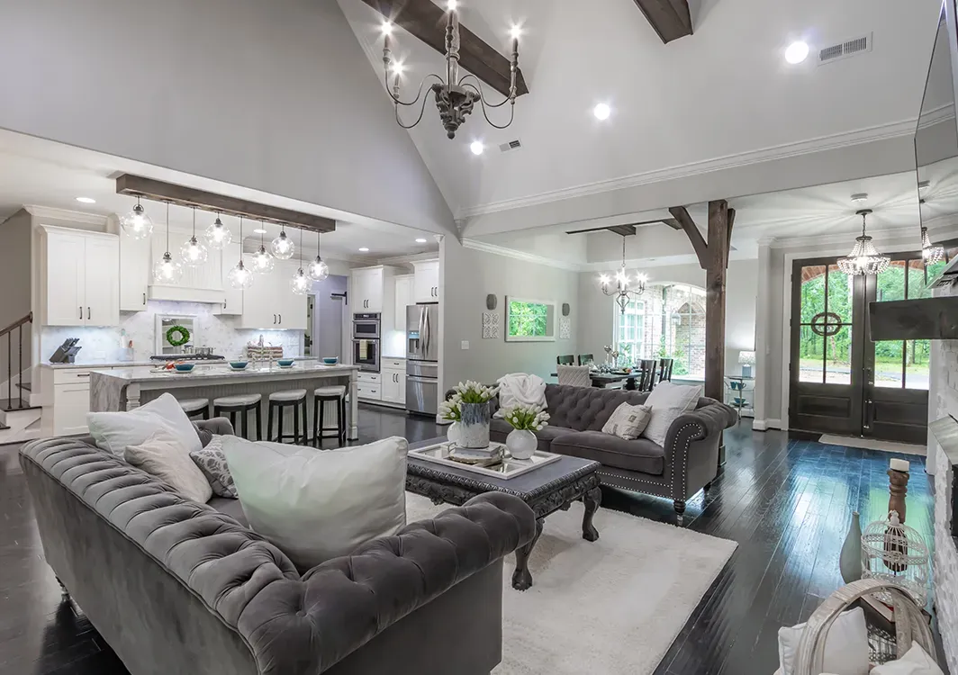 a living room filled with furniture and a kitchen in a house .