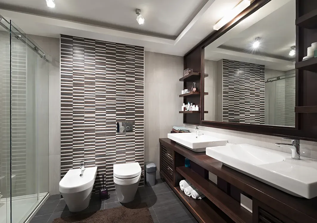 a bathroom with two sinks , a toilet , and a walk in shower .