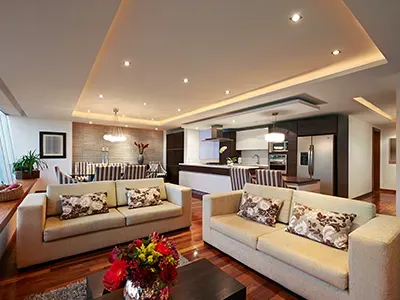a living room with two couches , a coffee table and a vase of flowers .