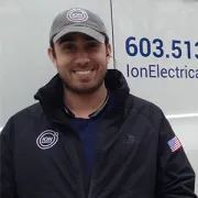 a man wearing a hat and a jacket is standing in front of a van .