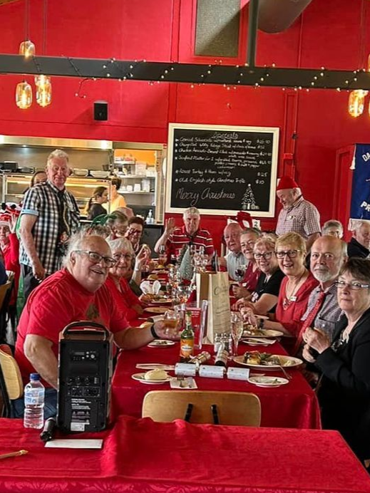 People in restaurant sitting on chairs at Christmas time.