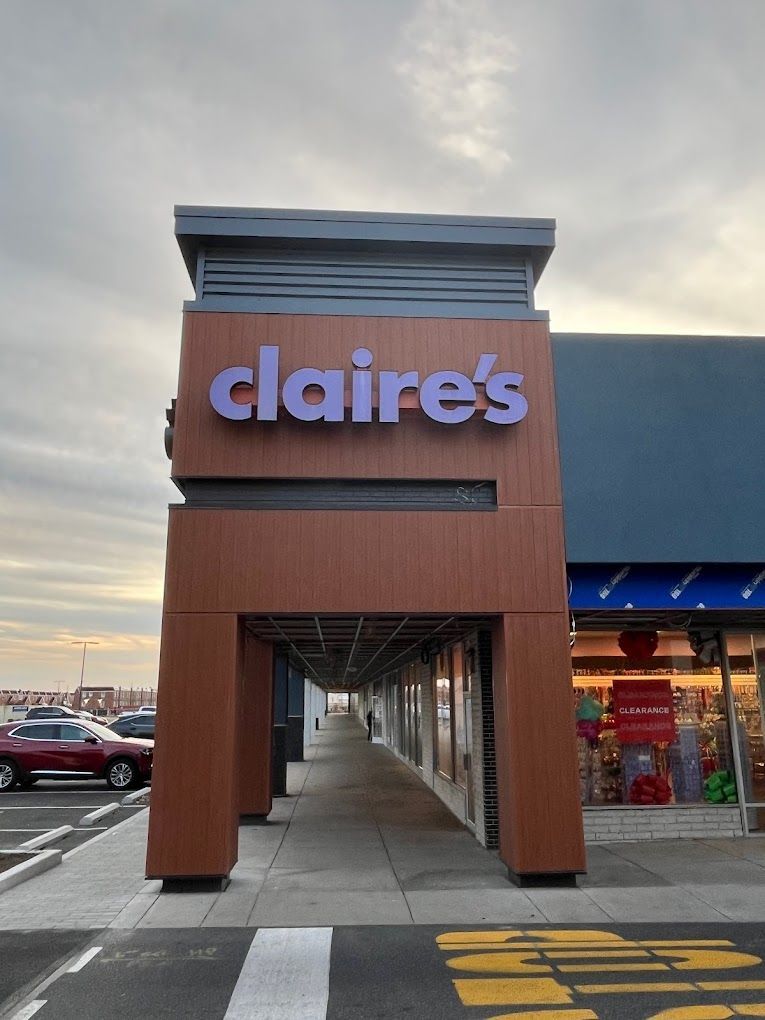The front of a claire 's store with cars parked in front of it