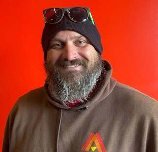 A man with a beard wearing a beanie and sunglasses.