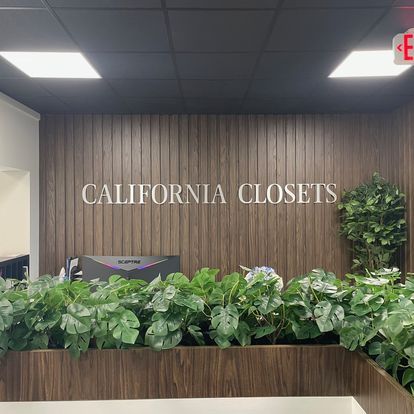 A sign for california closets is on a wooden wall