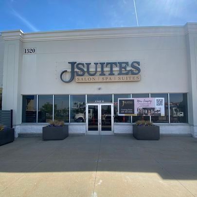 A white building with a sign that says jsuites salon spa suites.