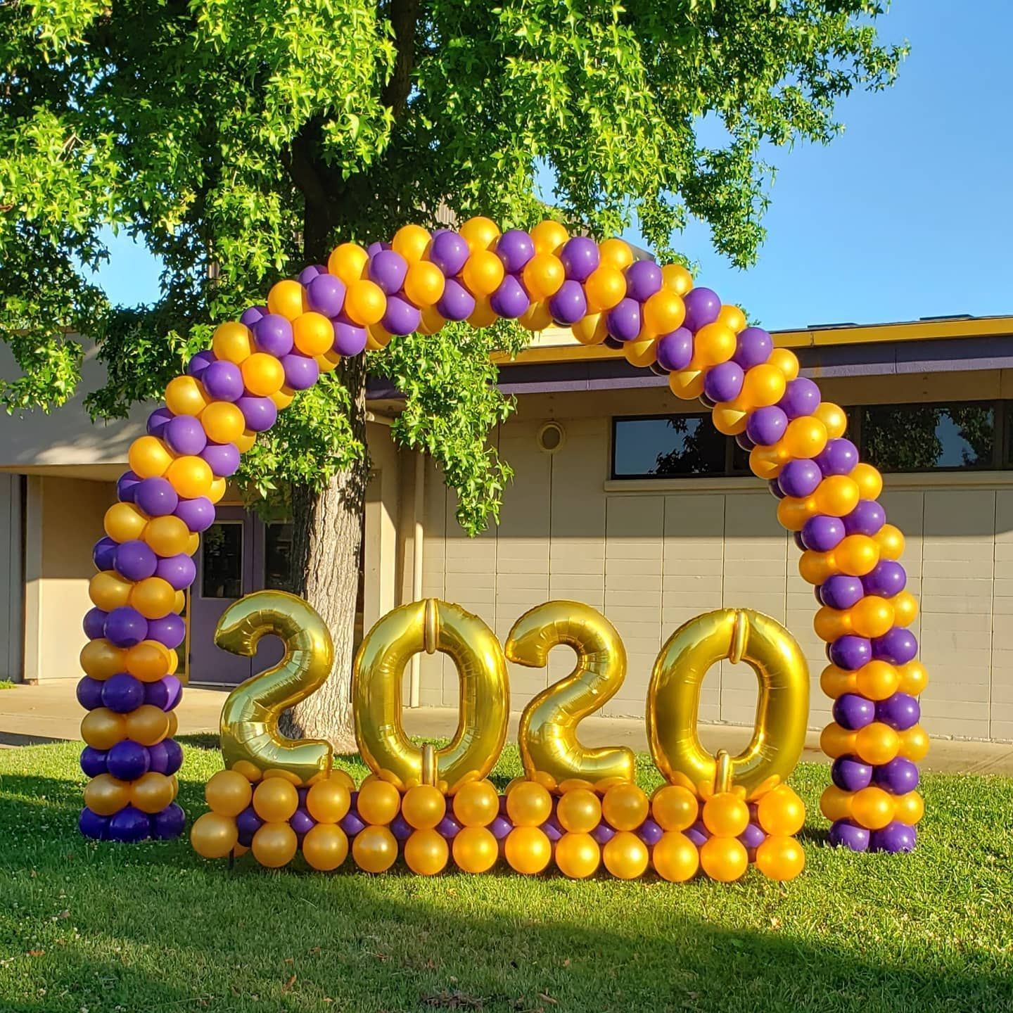 A purple and gold balloon arch with the numbers 2020 on it