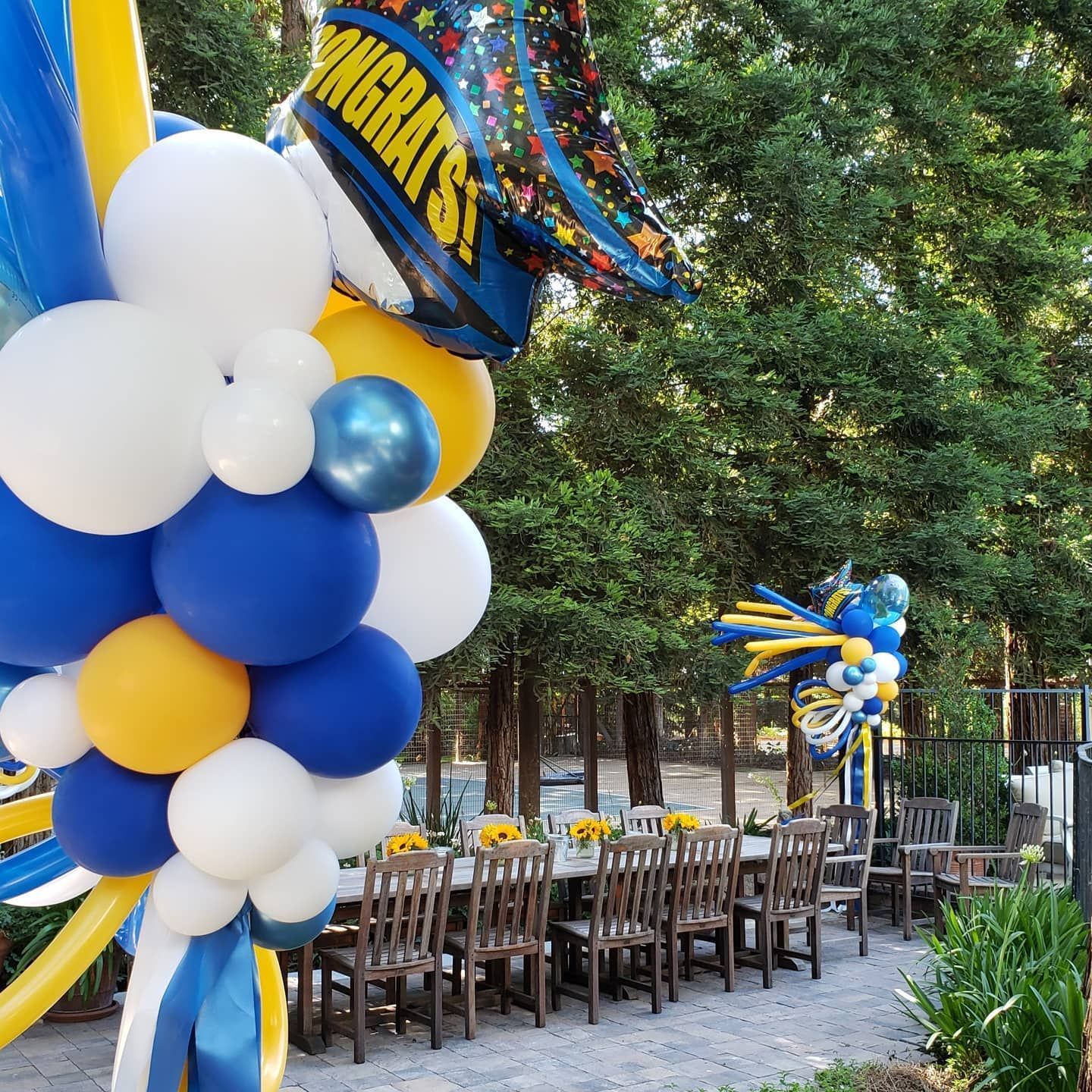 A bunch of balloons with one that says congrats on it