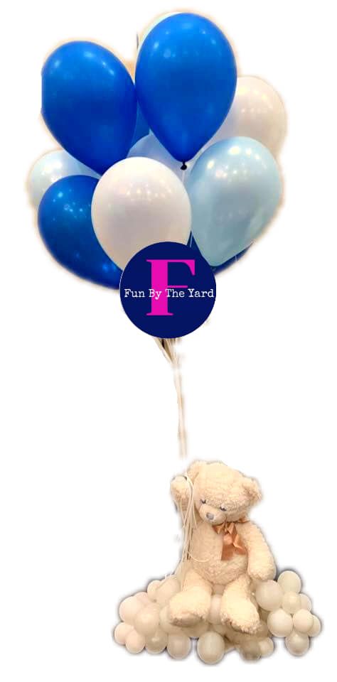 A teddy bear is sitting under a bunch of blue and white balloons.
