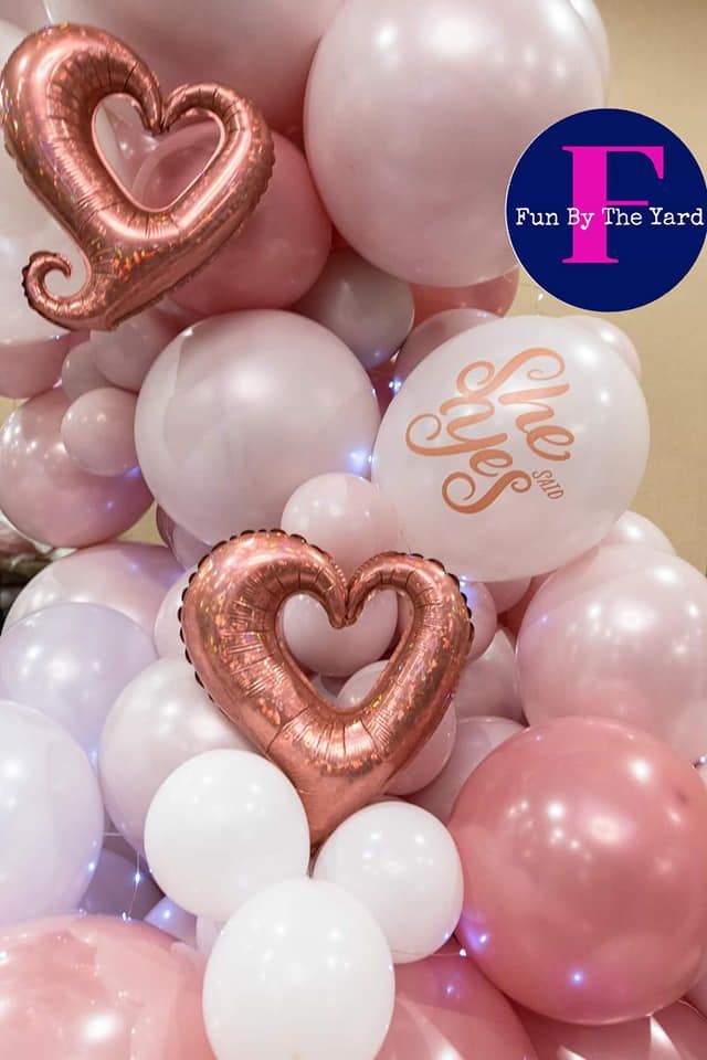 A bunch of pink and white balloons with hearts on them
