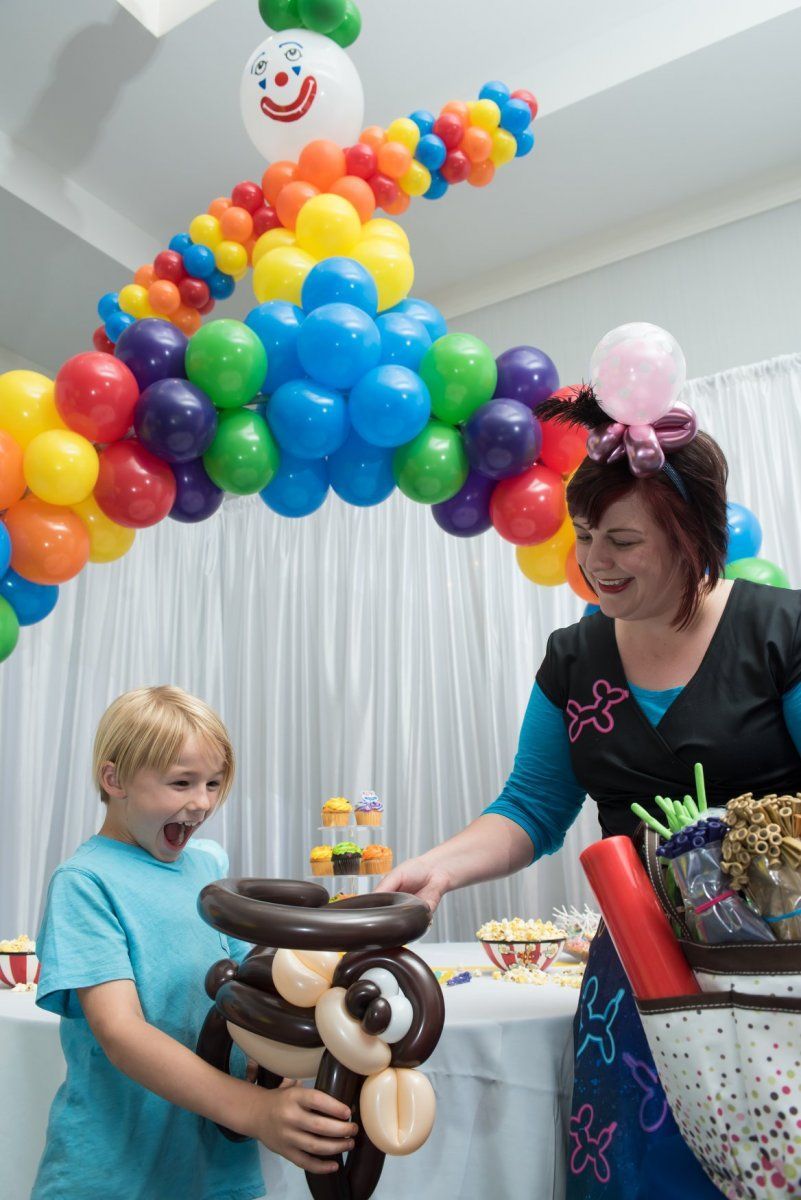 A woman and a boy are playing with balloons at a party.  Balloon Twisting Entertainment.