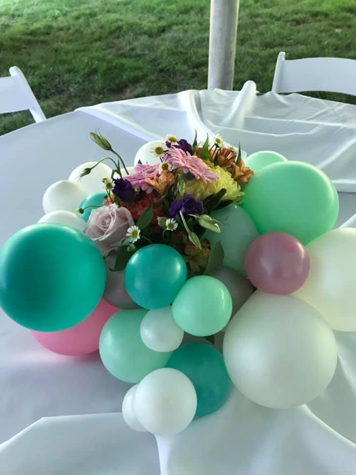 A table with balloons and flowers on it